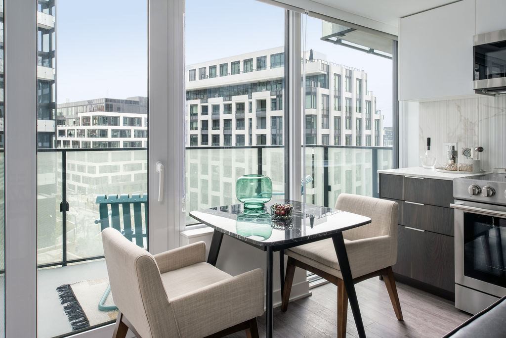 a living room with a table and chairs and a balcony